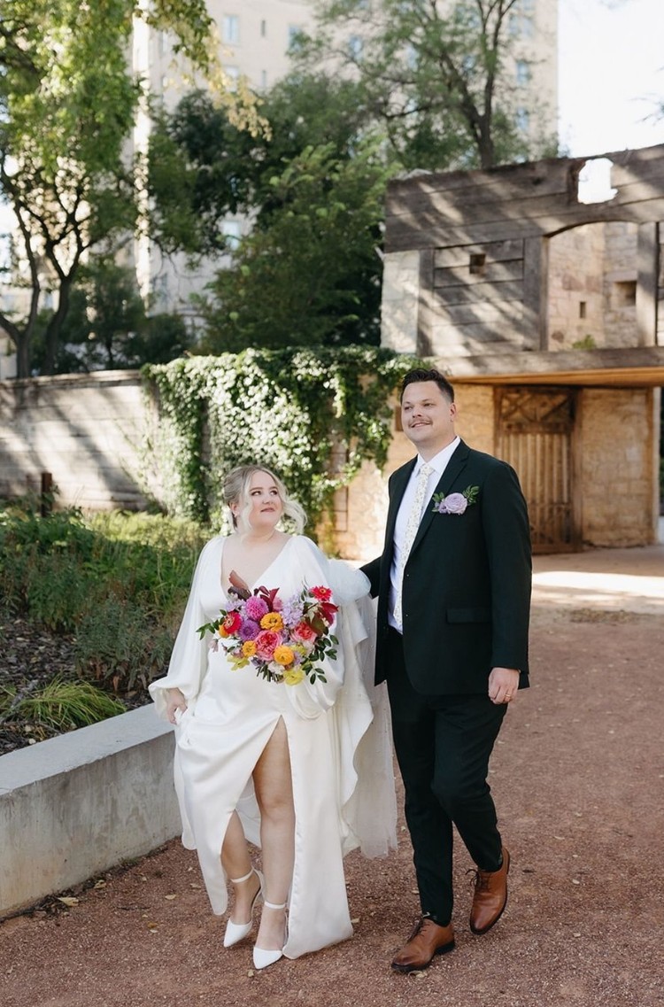 Groom in a custom-fit black suit walking with his bride, showcasing the perfect tailored look for every body type.